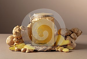 Ginger jam in small square jar and fresh ginger