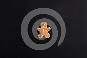 Ginger men with colored glaze on a black background . Gingerbread