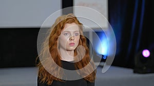 Ginger model walking on defile podium. Catwalk runway by redhead girl lace dress