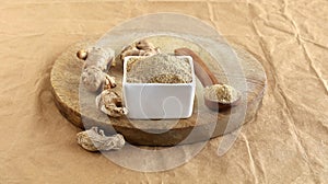 Ginger Powder in a Bowl and Raw and Dried Ginger on a Wooden Table