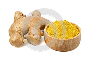 Ginger powder in a wooden cup and fresh ginger