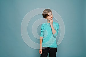 Ginger puzzled boy wearing long sleeve posing and looking aside