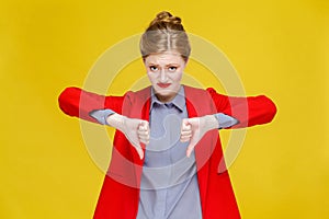 Ginger red head business woman in red suit showing dislike sign.