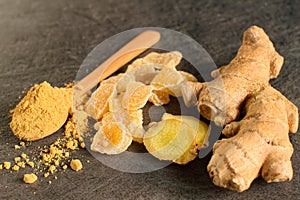 Ginger root, candied and ginger powder in wooden spoon