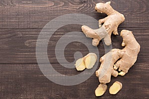 Ginger root on the wooden background. Top view