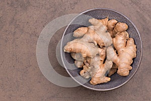 Ginger roots and on a brown textured background