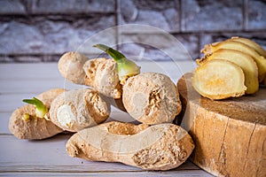 Ginger roots and ginger slices on the cutting board