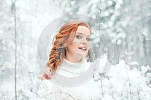 Ginger sweet girl in white sweater in winter forest. Snow december in park. Portrait. Christmas cute time.