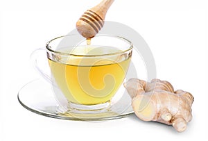 Ginger tea in glass cup and honey with fresh organic ginger root isolated on white