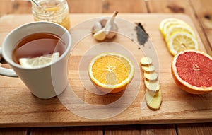 Ginger tea with honey, citrus and garlic on wood