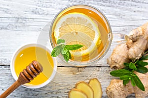 Ginger tea with lemon mint and honey on a white wooden background. Hot healthy winter drink