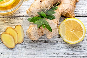 Ginger tea with lemon mint and honey on a white wooden background. Hot healthy winter drink