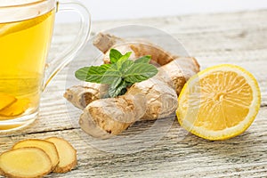 Ginger tea with lemon mint and honey on a white wooden background. Hot healthy winter drink