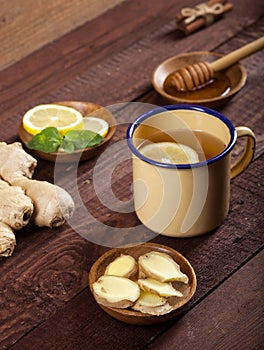 Ginger tea with lemon, mint and honey on wooden background