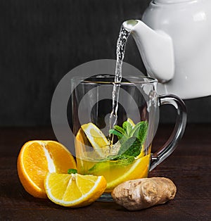 Ginger tea made from fresh orange and lemon slices. Pour boiling water into a transparent glass mug.