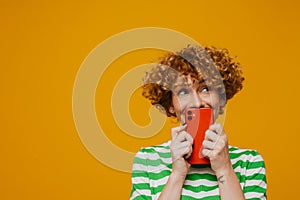 Ginger woman in striped t-shirt smiling and posing with cellphone