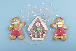 Gingerbread boy and girl with a gingerbread house on a blue background