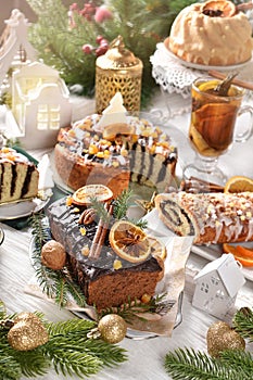 Gingerbread cake with chocolate glaze and poppy seed pastries on Christmas table