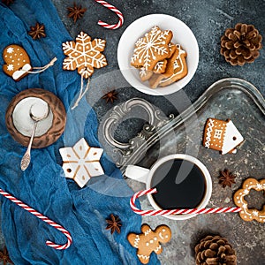 Gingerbread, candy cane and coffee cup on dark background. Christmas or New year composition. Flat lay. Top view