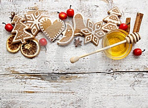 Gingerbread christmas cookies and bowl of honey on wooden table.