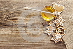 Gingerbread christmas cookies and bowl of honey on wooden table