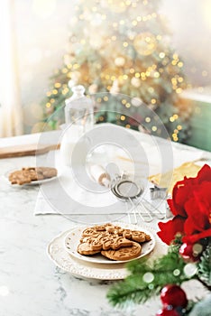 Gingerbread cookies on decorated kitchen near christmas tree. Vertical background