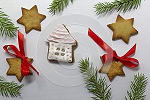 Gingerbread cookies and fir tree branches on white background. Christmas baking background. New Year theme. Merry