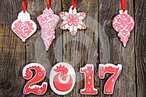 Gingerbread cookies hanging over wooden background