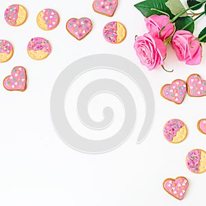 Gingerbread cookies and roses on white background. Frame, copy space. Flat lay. top view.