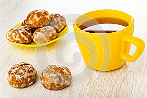 Gingerbread cookies in saucer, cookies, cup with hot tea on wooden table