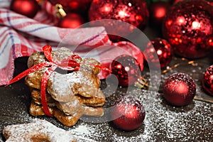 Gingerbread cookies in snow with christmas decorations vintage wooden table background.