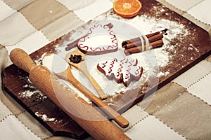 Gingerbread cookies, spices and flour over wooden background