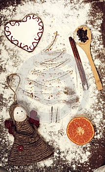 Gingerbread cookies, spices and flour over wooden background