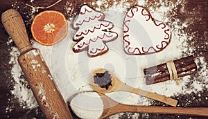 Gingerbread cookies, spices and flour over wooden background
