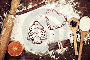 Gingerbread cookies, spices and flour over wooden background