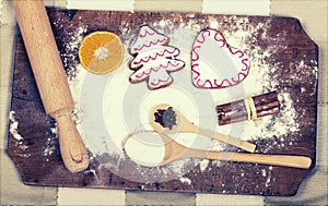 Gingerbread cookies, spices and flour over wooden cutting board