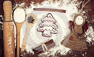 Gingerbread cookies, spices and flour over wooden cutting board