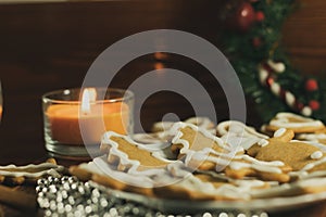 Gingerbread cookies in a white plate on a wooden table. Top view, free space for text. New Year\'s homemade baked goods.