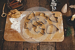 Gingerbread dough with christmas metal cutters on wooden board. Atmospheric Moody image. Making traditional christmas gingerbread