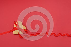 Gingerbread heart and red ribbon on red background, valentine`s day holiday. the mocap copyspace