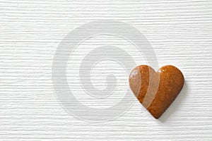 Gingerbread heart on a white background with a wood texture, can be used as a greeting card for Valentine`s Day