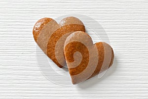 Gingerbread hearts on a white background with a wood texture, can be used as a greeting card for Valentine`s Day