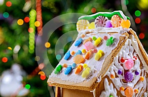 Gingerbread house on christmas tree lights background