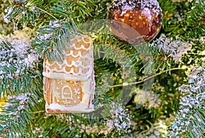 Gingerbread house with icing on a Christmas tree.