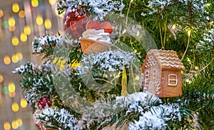 Gingerbread house with icing on a Christmas tree.