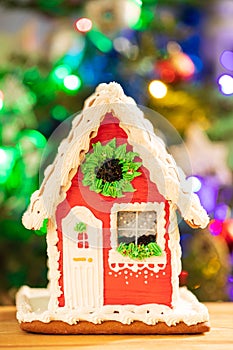 Gingerbread House On Table On Background Of Christmas Tree