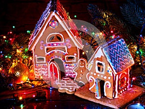 Gingerbread houses country with christmas lights string on wooden table.