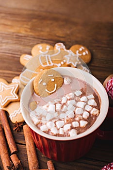 Gingerbread man bathes in a cup of chocolate or cocoa with marshmallow. Gingerbread Man in red cup