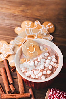 Gingerbread man bathes in a cup of chocolate or cocoa with marshmallow. Gingerbread Man in red cup