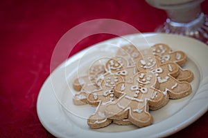 Gingerbread Man Cookes On Plate with Milk Resting on Red Table Cloth